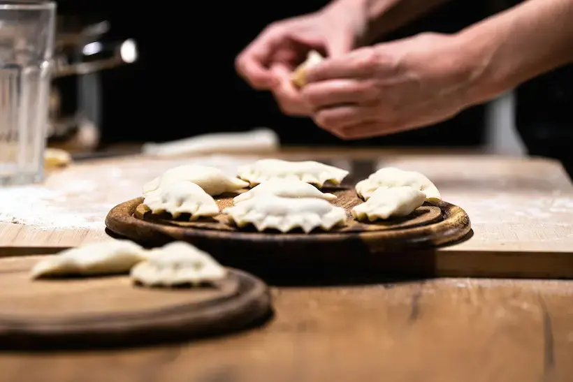 Handmade pierogi being folded during a cooking workshop