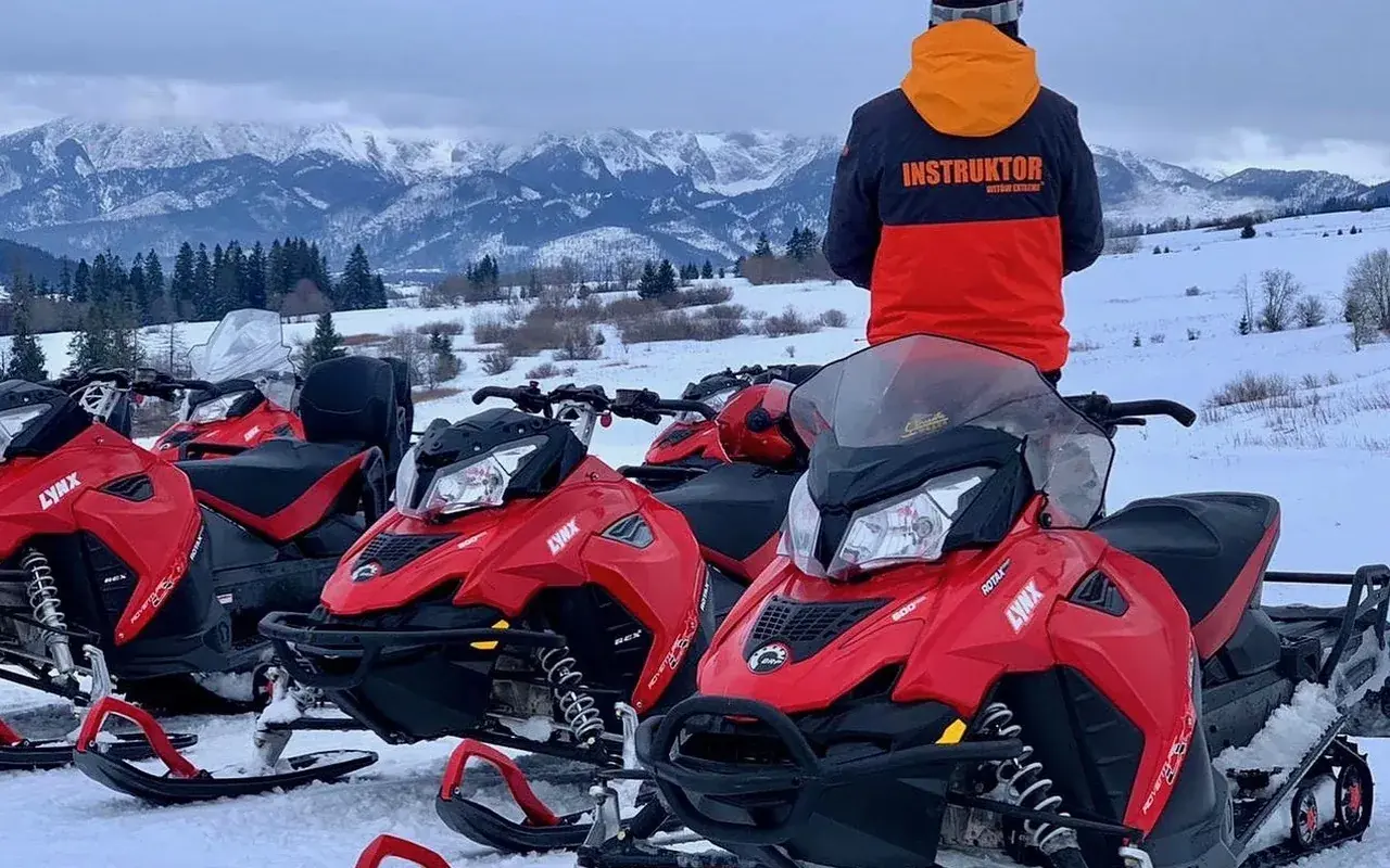 Red Lynx snowmobiles and instructor above a snowy Tatra valley near Witów
